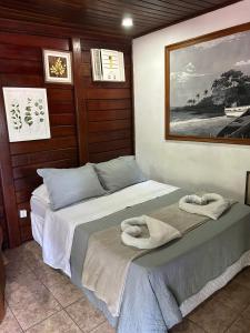 een slaapkamer met twee bedden met handdoeken erop bij Canoa Abraão - Ilha Grande RJ in Abraão +12 foto's