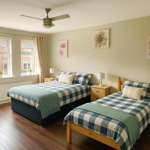 a bedroom with two beds and a ceiling fan at Newry Premium B&B in Newry