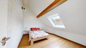 a bedroom with a bed with red pillows and a window at Mon petit chez soi en Alsace in Rountzenheim