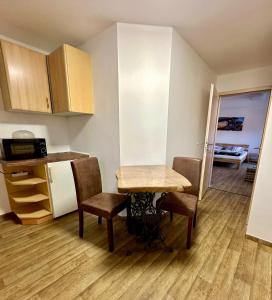 a small kitchen with a small table and chairs in a room at Ferienwohnung Gerdi in Hoyerswerda +2 photos