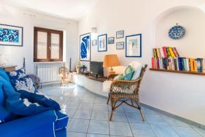 a living room with a blue couch and a desk at Mare Amore Fantasia in Gaeta