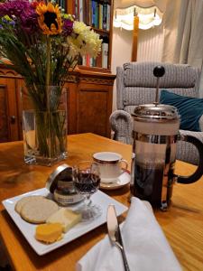 a table with a plate of cheese and a vase of flowers at The Old Schoolhouse in Ranish +39 photos