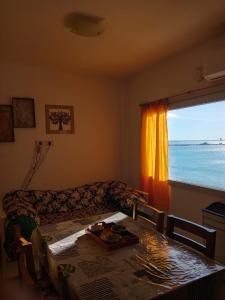 ein Wohnzimmer mit einem Tisch und einem Fenster mit Meerblick in der Unterkunft Atardecer Patagónico in Puerto Madryn