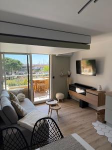 a living room with a couch and a television and a table at L'Original in Hyères