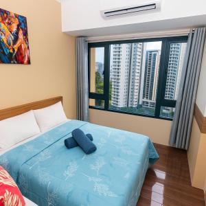 a bedroom with a blue pillow on a bed at Metro mood haven Makati relax recharge repeat 1765 in Manila