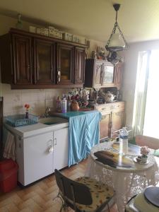a kitchen with a sink and a table with chairs at Chambre de la baronne de Rochegrosse in Saint-Maurice-en-Gourgois +8 photos