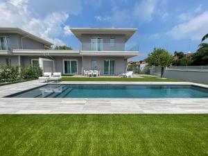 a house with a swimming pool in front of a yard at Polinesia 11 in Lido delle Nazioni
