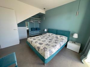 a bedroom with a bed and a blue wall at Polinesia 11 in Lido delle Nazioni +20 photos