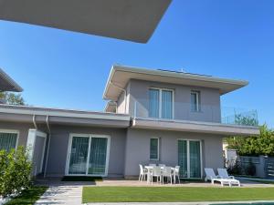 a house with white chairs and a patio at Polinesia 11 in Lido delle Nazioni