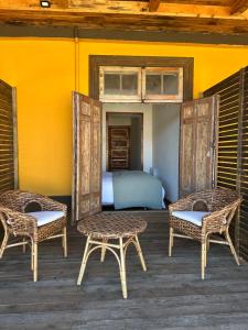 a bedroom with a bed and two wicker chairs at Casa Antigua Bed and Breakfast Chile in Casablanca