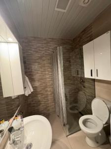 a bathroom with a toilet and a sink and a shower at Blue wave apartman in Bečići +15 photos