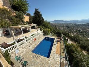 a villa with a swimming pool on a hill at Villa Mike's House in Apolpaina