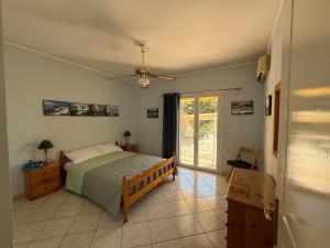 a bedroom with a bed and a ceiling fan at Villa Mike's House in Apolpaina +15 photos