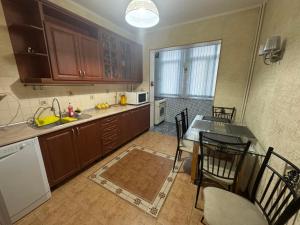 a kitchen with wooden cabinets and a table and chairs at Large Appartment & Central Place in Tashkent