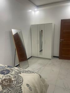 a bedroom with a bed and a dresser and a mirror at Magnifique in Dakan +1 photo