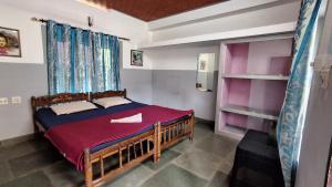 a bedroom with a bed and a book shelf at Swargam Pool Resort in Varkala