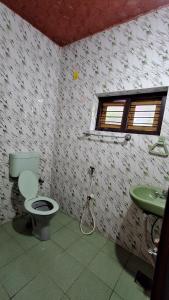 a bathroom with a toilet and a sink at Swargam Pool Resort in Varkala