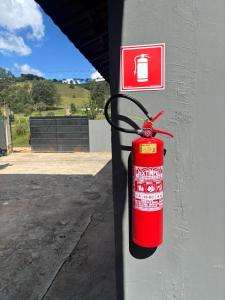a fire extinguisher attached to the side of a wall at Chalé Jaguary-Monte Verde in Companhia