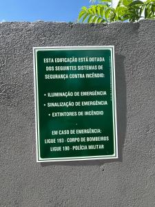 un cartello sul lato di un muro con alcune piante di Chalé Jaguary com hidro,Monte Verde MG a Companhia Altre 2 foto