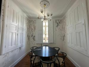 a dining room with a table and chairs and a window at Vestígios de Charme - Figueira Suits in Figueira da Foz