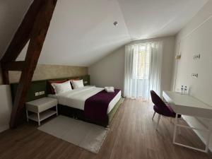 a bedroom with a bed and a desk and a table at Vestígios de Charme - Figueira Suits in Figueira da Foz