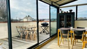 a room with a balcony with a table and chairs at Soleil & Sable in Dives-sur-Mer