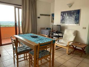 a living room with a dining room table and chairs at Casa San Pasquale, windsurf e natura, panorama mozzafiato in San Pasquale