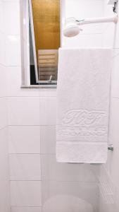 a bathroom with a white towel hanging on the wall at Hostel Flamengo in Rio de Janeiro