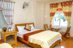 a bedroom with a bed and a window at Hoa Phuong Hotel Phong Nha in Phong Nha
