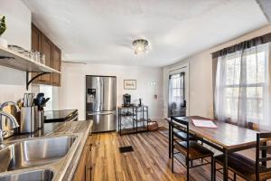 een keuken met een tafel en een roestvrijstalen koelkast bij Hudson Ave Loft in Sturgeon Bay