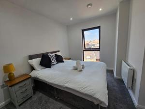 a bedroom with a large white bed with a window at 2 Bedroom Flat in Belfast in Belfast