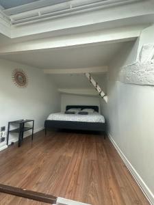a bedroom with a bed and a wooden floor at Charmant duplex in Clermont-Ferrand
