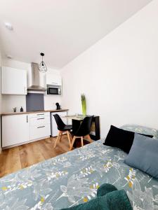 Un dormitorio con una cama y una mesa y una cocina. en Studio 2 Cosy en centre-ville - Puy duFou, en Les Herbiers