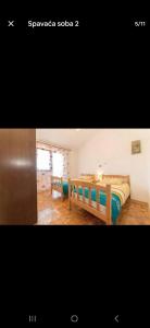 a picture of a bedroom with a bed and a table at Apartman Alar in Pridraga