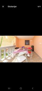 a room with a table and chairs and a balcony at Apartman Alar in Pridraga