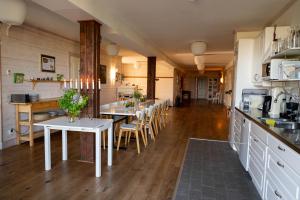 a kitchen and dining room with tables and chairs at Låsta Gårdshotell in Strängnäs