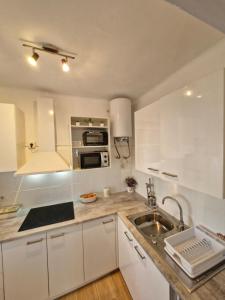 a kitchen with white cabinets and a sink at Bon Repos 2 in Torroella de Montgrí