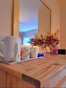 a counter top with a mirror and cups on it at Newry Premium B&B in Newry