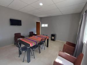 a conference room with a table and chairs and a television at Departamento Tranquilidad y descanso in General Alvear