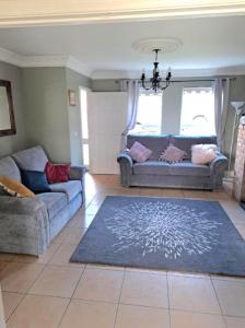 a living room with two couches and a rug at Newry Premium B&B in Newry