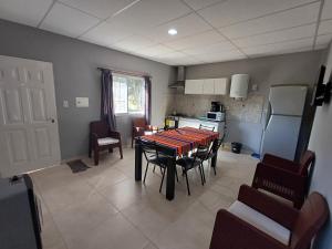 a living room with a table and chairs and a kitchen at Departamento Tranquilidad y descanso in General Alvear