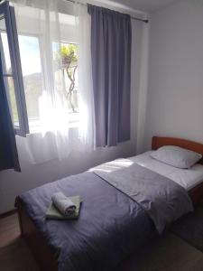 a bed in a bedroom with a window with a towel on it at Apartman Vera in Bileća +12 photos