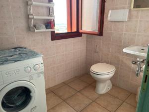 a bathroom with a washing machine and a toilet at Casa San Pasquale, windsurf e natura, panorama mozzafiato in San Pasquale