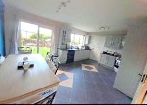 a large kitchen with white cabinets and a table at Newry Premium B&B in Newry