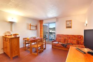 a living room with a couch and a table at Les Balcons Du Soleil in Font-Romeu