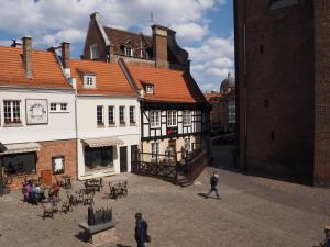 a group of people walking in a courtyard of a building at Grand-Tourist Posejdon Apartments in Gdańsk