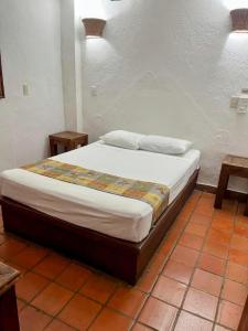 a bedroom with a bed in a room with two tables at HUX Express-Huatulco in Santa Cruz Huatulco +12 photos