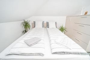 a bed in a white room with plants at Bloc nou cu parcare privata - Hella apartament in Giroc