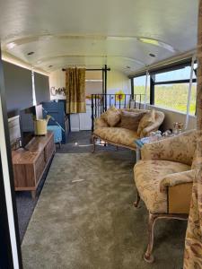 a living room with couches and a tv in a bus at The Bus On The Hill in Huntsham