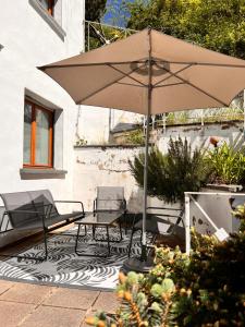 a patio with two chairs and an umbrella at Californication in Schoenecken